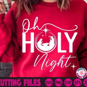 May include: Red sweatshirt with white text that reads "Oh Holy Night" with a star and a nativity scene graphic.
