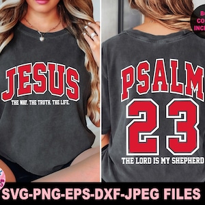 May include: Dark gray t-shirt with the word "JESUS" in red block letters outlined in white on the front. The text "THE WAY. THE TRUTH. THE LIFE." is below. The back of the shirt displays "PSALM 23" and "THE LORD IS MY SHEPHERD".