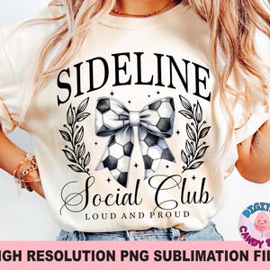 May include: White t-shirt with black text that reads "Sideline Social Club Loud and Proud". A black and white football bow is centered on the shirt.