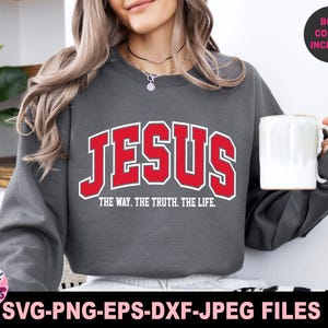 May include: A gray sweatshirt with the word "JESUS" in red block letters with a white outline. Below the word "JESUS" is the text "THE WAY. THE TRUTH. THE LIFE." The image also includes the text "BOTH COLORS INCLUDED" and "SVG-PNG-EPS-DXF-JPEG FILES."