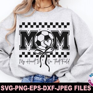 May include: A gray sweatshirt with a black and white design featuring a soccer ball, the word "MOM", and the text "My Heart Is On That Field".