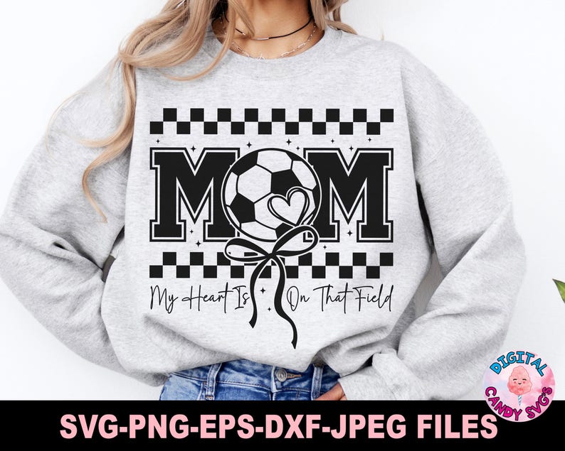 May include: A gray sweatshirt with a black and white design featuring a soccer ball, the word "MOM", and the text "My Heart Is On That Field".
