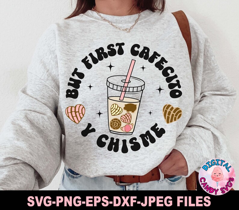 May include: A gray sweatshirt with the text "But first cafecito y chisme" in black and white. The text is surrounded by a circle with a brown and pink heart on each side. Inside the circle is a glass of iced coffee with brown and pink pastries.