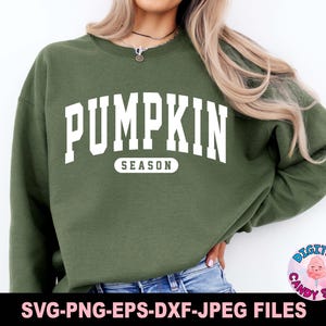 May include: A green sweatshirt with the text "PUMPKIN SEASON" in white letters. The sweatshirt is a popular fall fashion item.