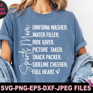 May include: A blue t-shirt with white text that reads "Sports Mom" and a list of duties: "Uniform Washer, Water Filler, Ride Giver, Picture Taker, Snack Packer, Sideline Cheer, Full Heart."