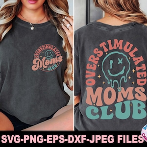 May include: Dark gray t-shirt with the text "OVERSTIMULATED MOMS CLUB" in a retro design. The front of the shirt has a circular logo, and the back features a larger design with a melting smiley face.