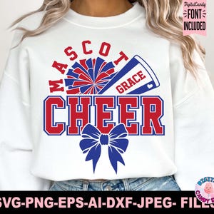 Può includere: Una felpa bianca a maniche lunghe con un design grafico che include il testo MASCOT, CHEER e GRACE. Il design presenta un pon-pon rosso e blu, un megafono blu e un grande fiocco blu. Il testo è in un carattere in grassetto a blocchi.