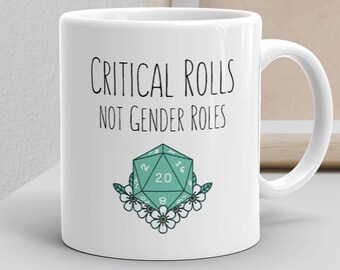 May include: White ceramic mug with a black and green design. The mug features the text "Critical Rolls Not Gender Roles" and a green 20-sided die with white numbers surrounded by white flowers.
