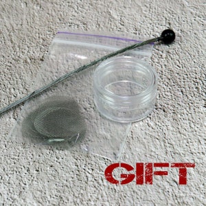 May include: A clear, small jar, a metal mesh screen, and a metal tool with a black ball end are displayed on a textured surface. The items are inside a clear plastic bag. The word "GIFT" is stamped in red.