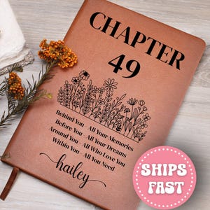 May include: A brown leather journal with the text "CHAPTER 49" in large black letters. Below, a floral design and the words "Behind You - All Your Memories, Before You - All Your Dreams, Around You - All Who Love You, Within You - All You Need" are printed. The name "hailey" is also printed.