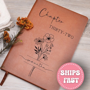 May include: A brown leather-bound journal with the words "Chapter THIRTY-TWO" and the name "Samantha" printed on the cover. A floral design is also featured. A pink circle with the words "SHIPS FAST" is in the bottom right corner.