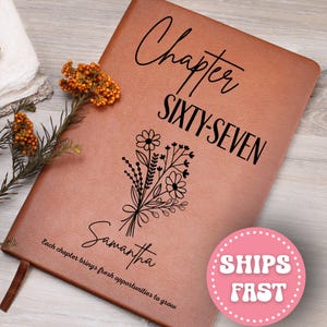 May include: A brown leather journal with the words "Chapter SIXTY-SEVEN" and the name "Samantha" printed on the cover. A floral bouquet design is also featured. The text "Each chapter brings fresh opportunities to grow" is printed at the bottom.