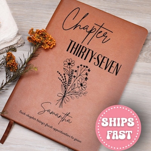 May include: A brown leather journal with the words "Chapter THIRTY-SEVEN" and the name "Samantha" printed on the cover. A floral bouquet design is also featured. The journal has a ribbon bookmark and the text "Each chapter brings fresh opportunities to grow".