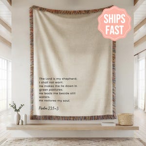 May include: Cream-colored throw blanket with a fringed border in shades of brown, red, and orange. The blanket features the text "The Lord is my shepherd; I shall not want...Psalm 23:1-3". A pink "SHIPS FAST" sticker is in the upper right corner.