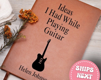 May include: A brown leather journal with the text "Ideas I Had While Playing Guitar" and a black guitar silhouette. The name "Helen Johnson" is printed at the bottom. A pink circle with the text "SHIPS NEXT DAY" is in the bottom right corner.