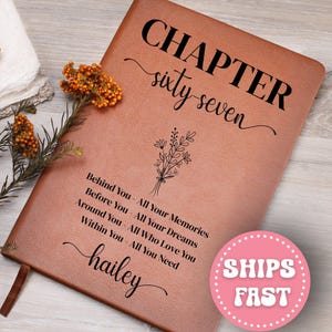 May include: A brown leather journal with the words "CHAPTER sixty seven" in black script. Below the title is a floral design and the text "Behind You - All Your Memories, Before You - All Your Dreams, Around You - All Who Love You, Within You - All You Need, hailey."