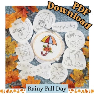 May include: A PDF download pattern set for embroidery featuring a central hoop with a colorful umbrella and pumpkin design. Surrounding it are white fabric patches with black line art of a cat, umbrella, cloud, boots, and leaves, labeled Rainy Fall Day.