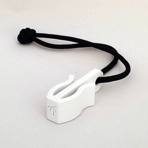 May include: A white plastic zipper pull with a black cord. The pull has a curved design with a slot and a small palm tree logo. The black cord is knotted at the end.