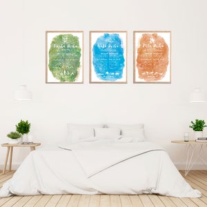 May include: Three framed watercolor prints with a white background and white text. The prints are titled "Papa Birtha", "Mama Birtha", and "Mila Birtha". The prints are hanging on a white wall above a white bed with white bedding.