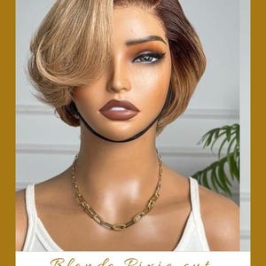 Könnte beinhalten: Blonder Pixie-Cut-Perücke mit dunkelbraunen Ansätzen und Seitenscheitel. Die Perücke ist mit weichen Wellen und einem natürlich aussehenden Haaransatz gestylt. Eine goldene Kette wird um den Hals getragen. Der Text "Blonde Pixie cut" steht unten.