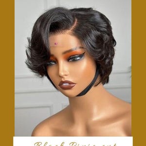 May include: A black pixie cut wig styled on a mannequin head. The wig has short, wavy layers and a side parting. The text "Black Pixie cut" is displayed in a white box below the mannequin.