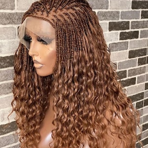 May include: A brown wig with small braids and loose curls. The wig is styled with a lace front and is ready to be worn.