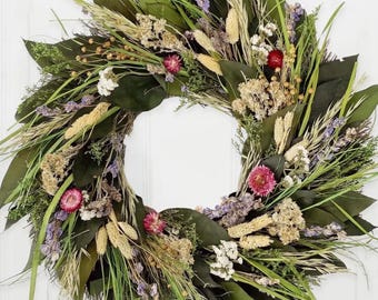 Corona floral primaveral artesanal de 45 cm: flores y follaje en tonos pastel.