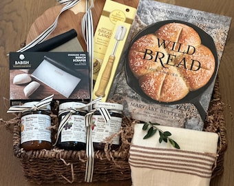 Cesta de regalo para elaborar pan de masa madre artesanal, bandeja de mimbre, libro de recetas, mermeladas, cuchilla para pan y raspador.