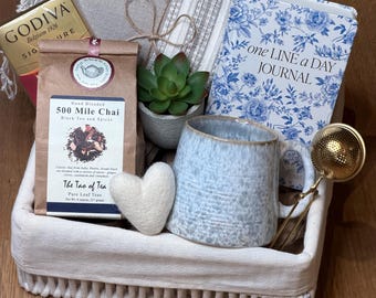 Cesta de regalo para relajarse, manta acogedora, té orgánico, taza de cerámica.