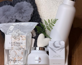 Cesta de regalo de spa con zapatillas, manta, vela, vaporizadores de ducha y jabón.