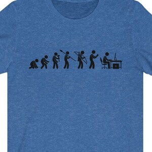 May include: A blue t-shirt with a black graphic of the evolution of man, ending with a person sitting at a computer.