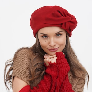 Woman in a red beret with a bow, set against a white background.