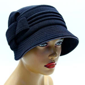 Dark blue cloche hat on a mannequin, against a white background.