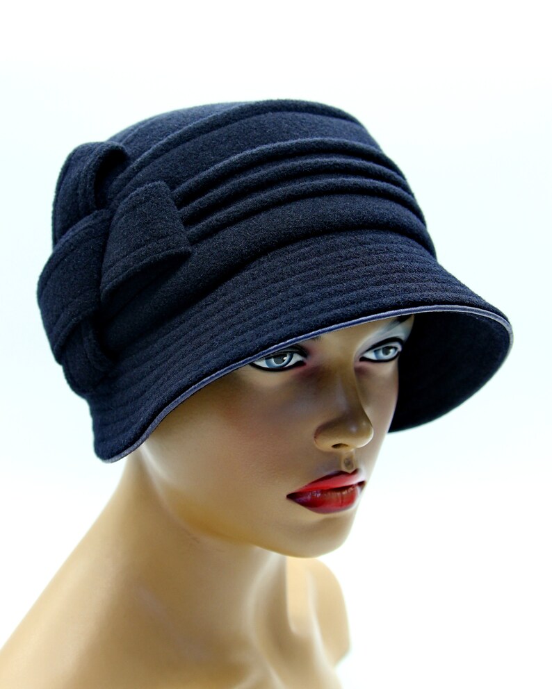 Dark blue cloche hat on a mannequin, against a white background.