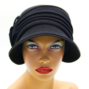 Black cloche hat displayed on a mannequin, set against a white background