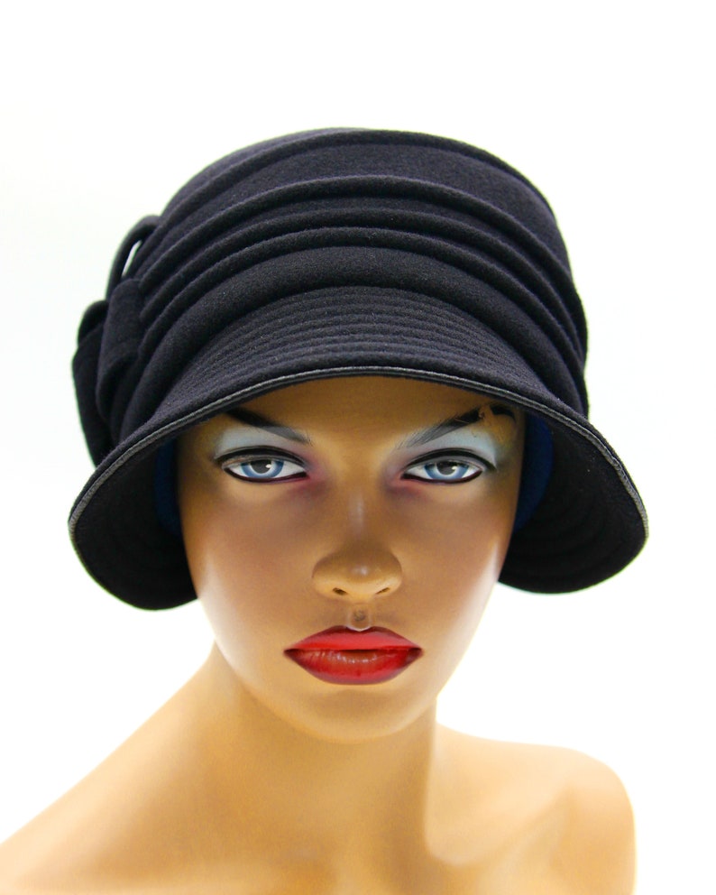 Black cloche hat displayed on a mannequin, set against a white background