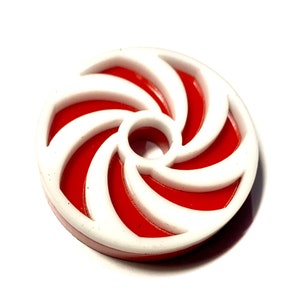 May include: A red and white candy cane swirl design on a round plastic disc.