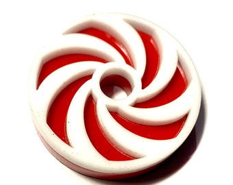 May include: A red and white candy cane swirl design on a round plastic disc.