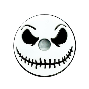 Puede incluir: Adorno de cerámica blanca con un diseño de cara de Jack Skellington en blanco y negro. La cara tiene una boca cosida y dos ojos negros.