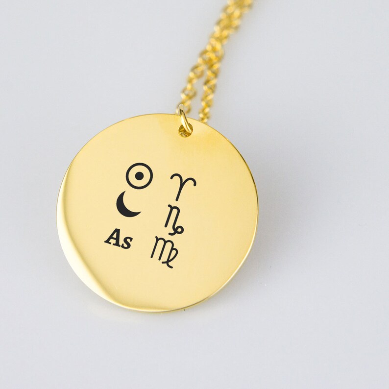 Pu&ograve; includere: Collana d'oro con un ciondolo rotondo che presenta simboli astrologici. Il ciondolo ha i simboli del sole, della luna, Ariete, Scorpione e Vergine. Il testo "As" &egrave; anche inciso sul ciondolo.