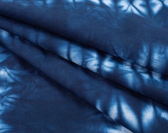 May include: Blue and white tie-dye fabric with a swirling pattern. The fabric is soft and has a slightly textured surface.