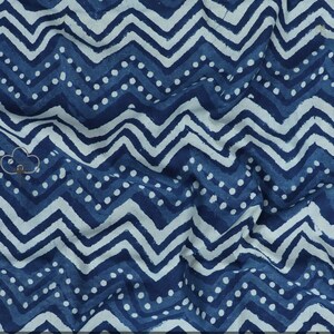 Puede incluir: Tela azul y blanca con un patrón de chevron y lunares blancos.