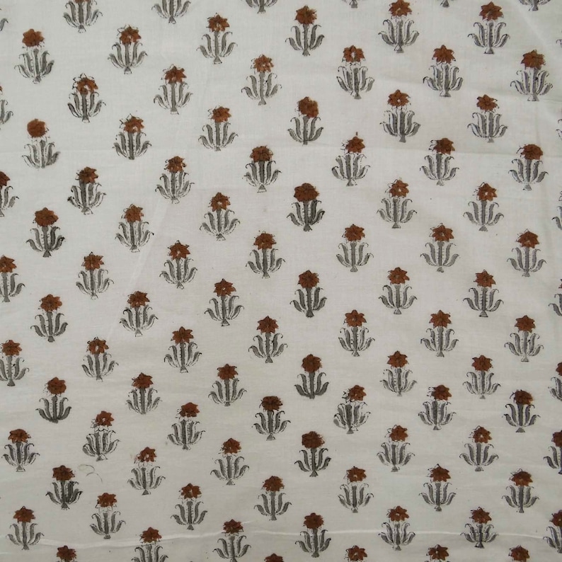 Grey White floral hand block print cotton fabric featuring traditional Indian artisan craftsmanship on soft lightweight cotton. This handmade Jaipur block printed fabric is shown in a swirl drape to highlight its smooth texture, natural flow, and elegant floral motif. Perfect for dressmaking, quilting, sewing, kurtas, summer dresses, blouses, home décor, DIY crafts, and fabric by the yard projects. 
 
block print fabric, fabric by the yards, cotton fabric, hand dyed fabric, Indian cotton fabric