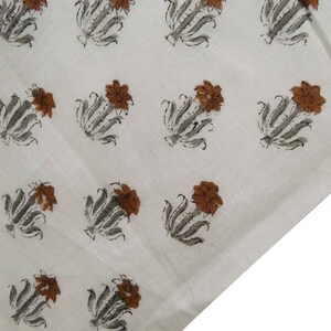 Grey White floral hand block print cotton fabric featuring traditional Indian artisan craftsmanship on soft lightweight cotton. This handmade Jaipur block printed fabric is shown in a swirl drape to highlight its smooth texture, natural flow, and elegant floral motif. Perfect for dressmaking, quilting, sewing, kurtas, summer dresses, blouses, home décor, DIY crafts, and fabric by the yard projects. 
 
block print fabric, fabric by the yards, cotton fabric, hand dyed fabric, Indian cotton fabric