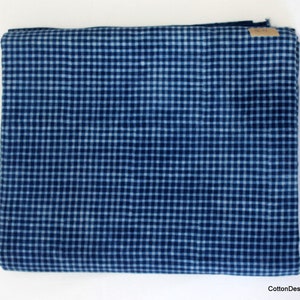 May include: A folded piece of blue and white gingham fabric. The fabric has a small checkered pattern.