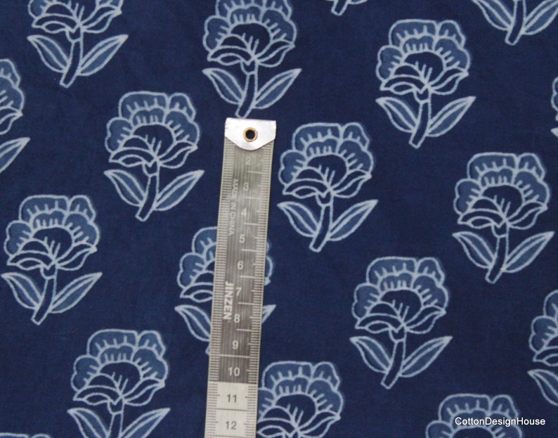 Hand block printed 100% cotton fabric featuring a traditional Indian floral pattern with intricate artisan detailing. Soft, breathable, lightweight fabric sold by the yard, ideal for sewing dresses, blouses, skirts, quilting, patchwork, home décor, cushion covers, curtains, table linens, tote bags, and a variety of DIY craft projects. Perfect for fashion designers, crafters, and handmade creations.
