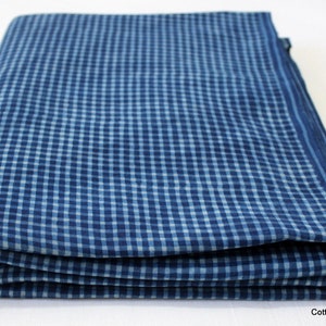 May include: A folded blue and white gingham fabric. The fabric has a checkered pattern.