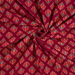 Hand block printed 100% cotton fabric featuring a traditional Indian floral pattern with intricate artisan detailing. Soft, breathable, lightweight fabric sold by the yard, ideal for sewing dresses, blouses, skirts, quilting, patchwork, home décor, cushion covers, curtains, table linens, tote bags, and a variety of DIY craft projects. Perfect for fashion designers, crafters, and handmade creations.