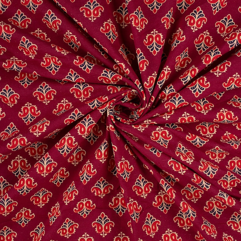 Hand block printed 100% cotton fabric featuring a traditional Indian floral pattern with intricate artisan detailing. Soft, breathable, lightweight fabric sold by the yard, ideal for sewing dresses, blouses, skirts, quilting, patchwork, home décor, cushion covers, curtains, table linens, tote bags, and a variety of DIY craft projects. Perfect for fashion designers, crafters, and handmade creations.