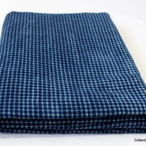May include: A folded blue and white gingham fabric. The fabric has a checkered pattern.